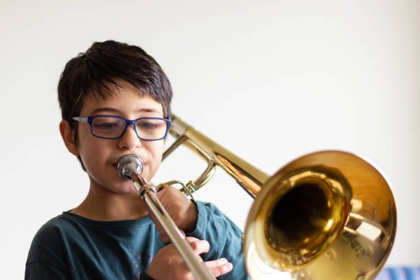 Boy playing trombone at home